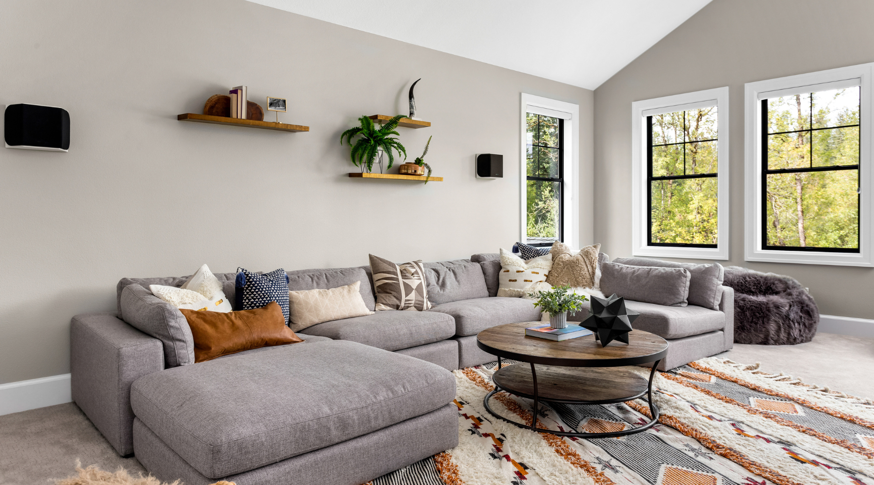 Spacious and well-designed living room featuring a large, comfortable couch, a stylish coffee table, and a focal point area rug. The neutral color scheme and thoughtful arrangement create a cozy and inviting atmosphere.