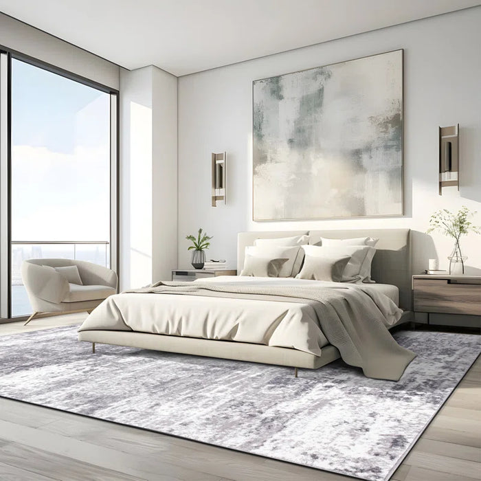 Modern bedroom featuring a large abstract painting above a beige bed, an armchair positioned by floor-to-ceiling windows, nightstands, and the Willington Abstract Ivory/Dark and Light Gray Area Rug.