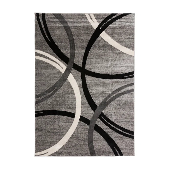 The Devonshire Abstract Gray/Black/Ivory Area Rug features a pattern of overlapping black, dark gray, and ivory curved lines forming abstract circular shapes.