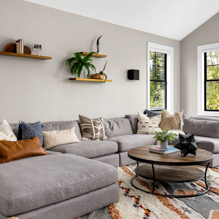 Spacious and well-designed living room featuring a large, comfortable couch, a stylish coffee table, and a focal point area rug. The neutral color scheme and thoughtful arrangement create a cozy and inviting atmosphere.