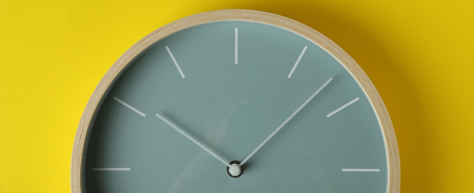 aqua colored clock on yellow wall