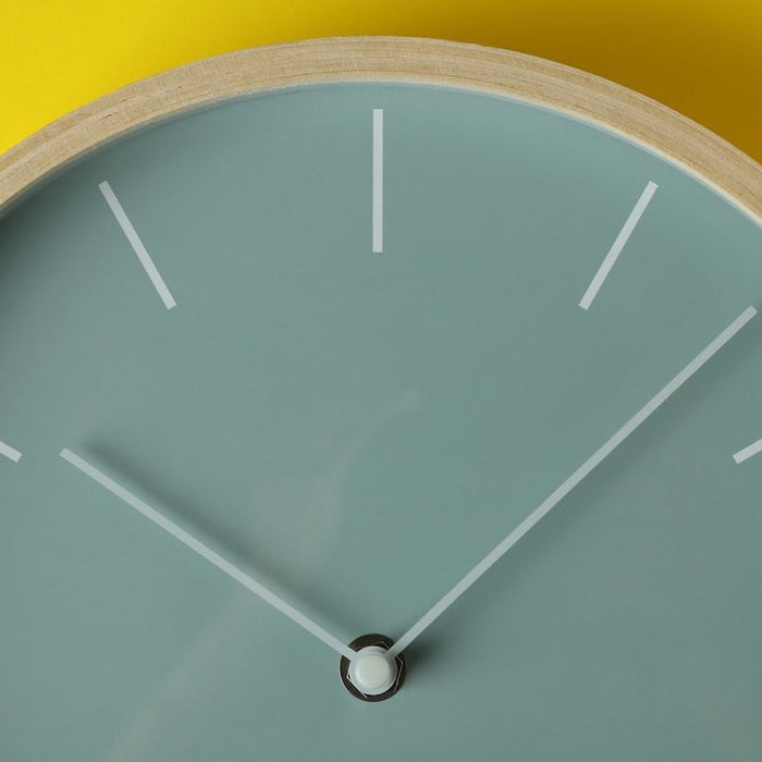 aqua colored clock on yellow wall