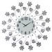 Decorative wall clock with floral and leaf designs on a white background