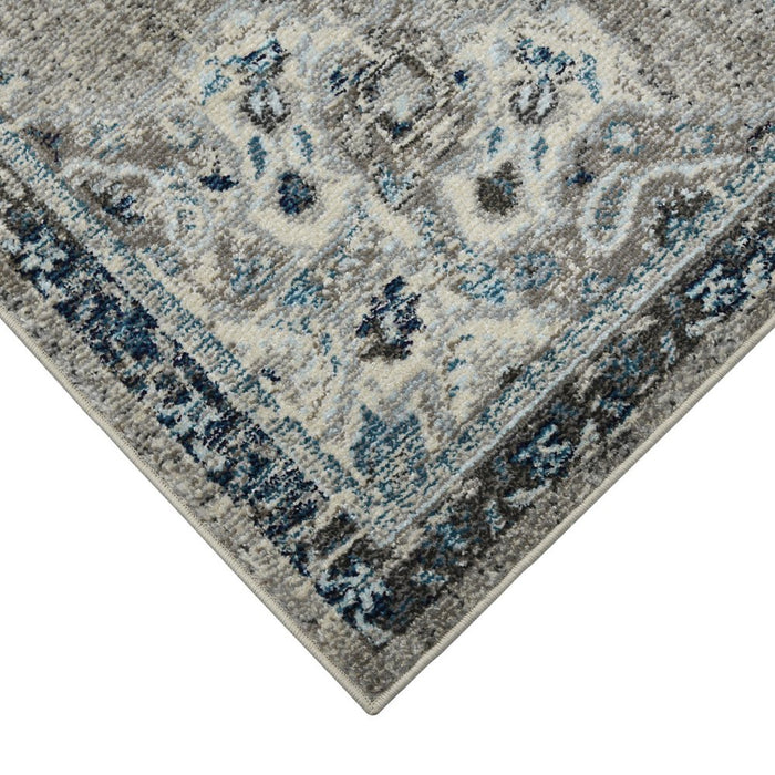 Close-up of a patterned rug with blue and gray colors on a white background