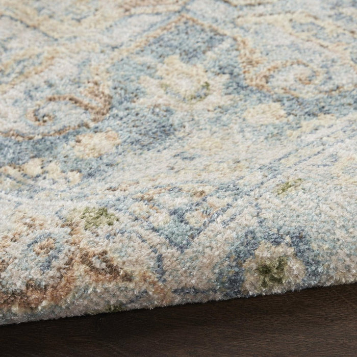 Close-up of a patterned rug with blue and beige colors.