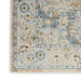 Close-up of a patterned rug with floral designs in blue, beige, and green.