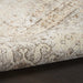 Close-up of a textured beige rug with intricate patterns on a dark surface.