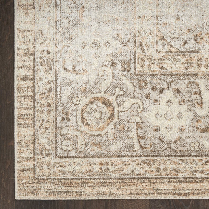 Close-up of a patterned rug with beige and brown colors on a wooden floor.