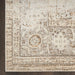 Close-up of a patterned rug with beige and brown colors on a wooden floor.
