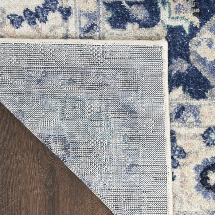 Close-up of a textured rug with a geometric pattern on a wooden floor.