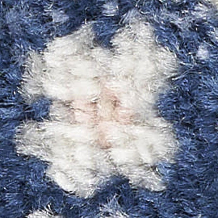 Close-up of a fluffy white rug on a blue textured surface