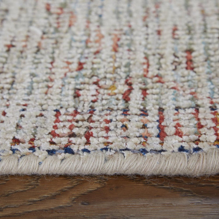 Close-up of a textured multicolored rug on a wooden floor