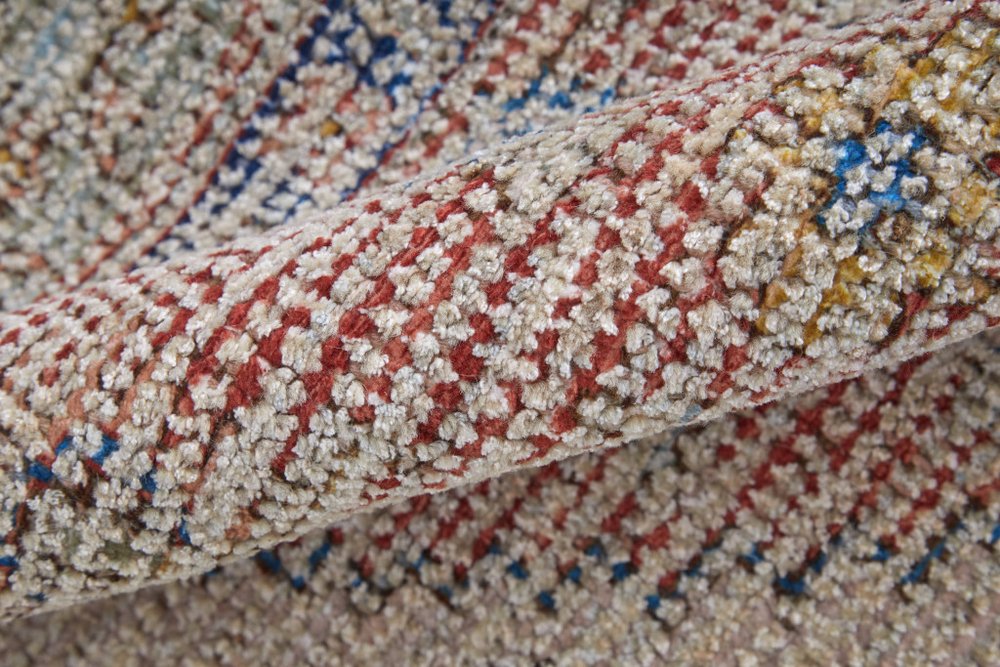 Close-up of a textured fabric with red, blue, and beige pattern