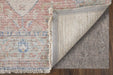 Close-up of a textured rug corner with a gray underlay on a wooden floor.