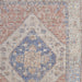 Close-up of a textured rug with a central floral design in blue and beige.