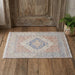 Decorative rug with geometric pattern on a wooden floor next to a wooden door.