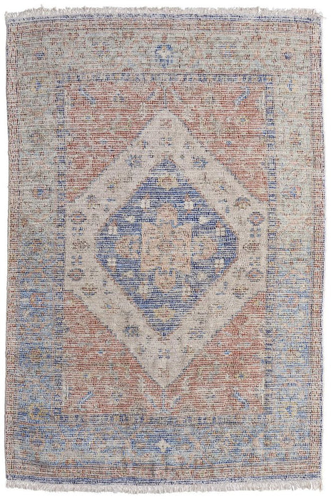 Rug with a geometric pattern featuring blue, red, and beige colors on a white background