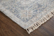 Textured area rug with fringes on a wooden floor