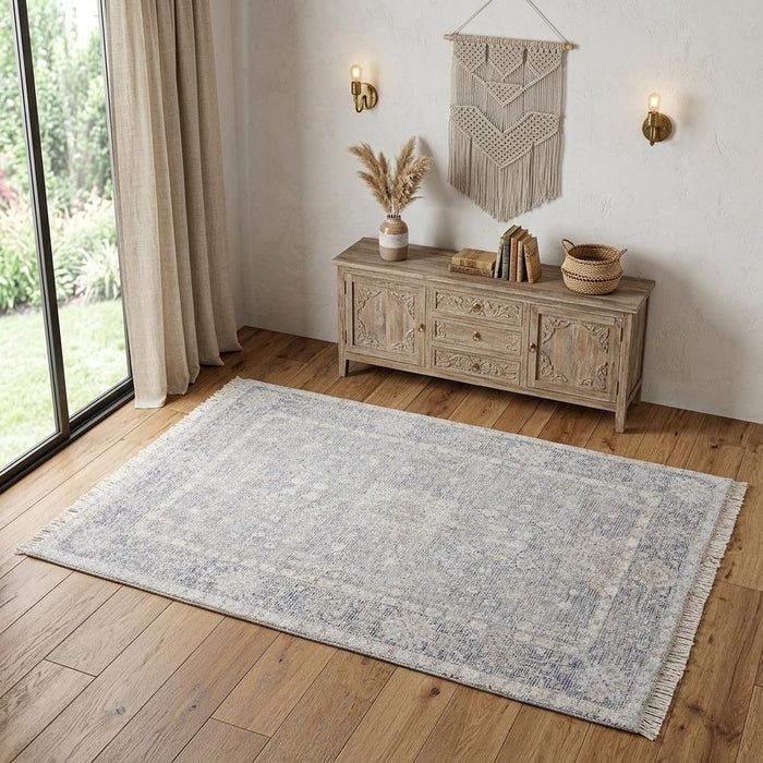 Living room with a wooden sideboard, rug, and decorative items.