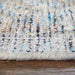 Close-up of a textured rug with multicolor pattern on wooden floor