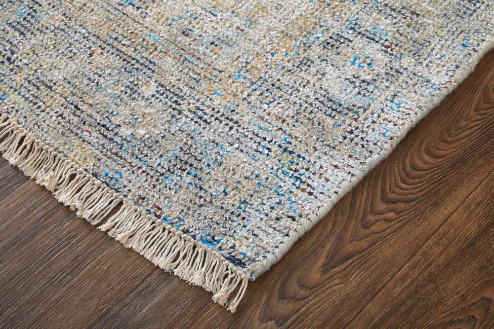 Textured area rug with fringes on a wooden floor