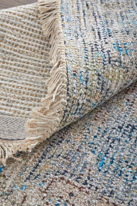 Textured rug with fringed edge and multicolor pattern