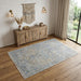 Room interior with wooden sideboard, rug, and decorative wall hanging.