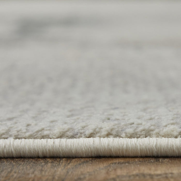 Close-up of a textured gray rug on a wooden floor