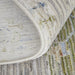Close-up of a textured rug with a focus on the border and pattern.