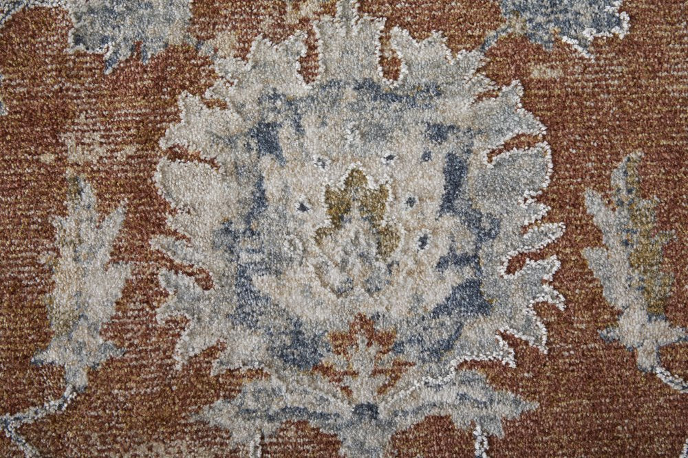 Close-up of a patterned rug with brown, beige, and blue colors.