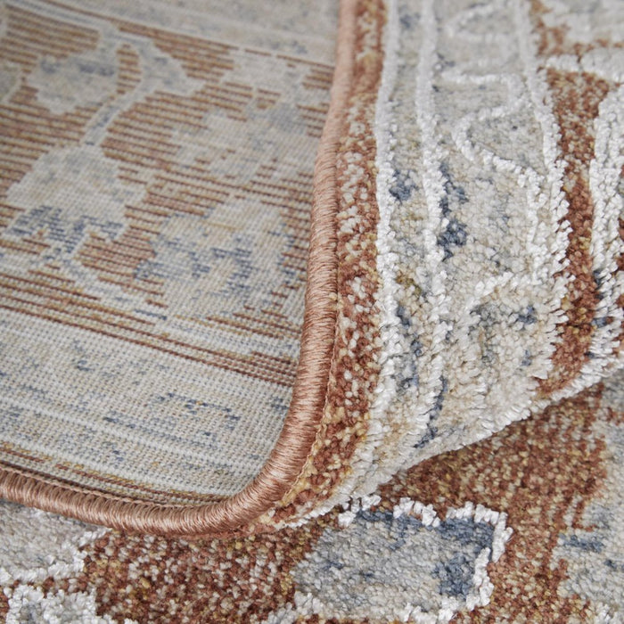 Close-up of a patterned rug with brown, beige, and blue colors.