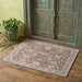 Decorative rug on a wooden floor with an ornate wooden door in the background