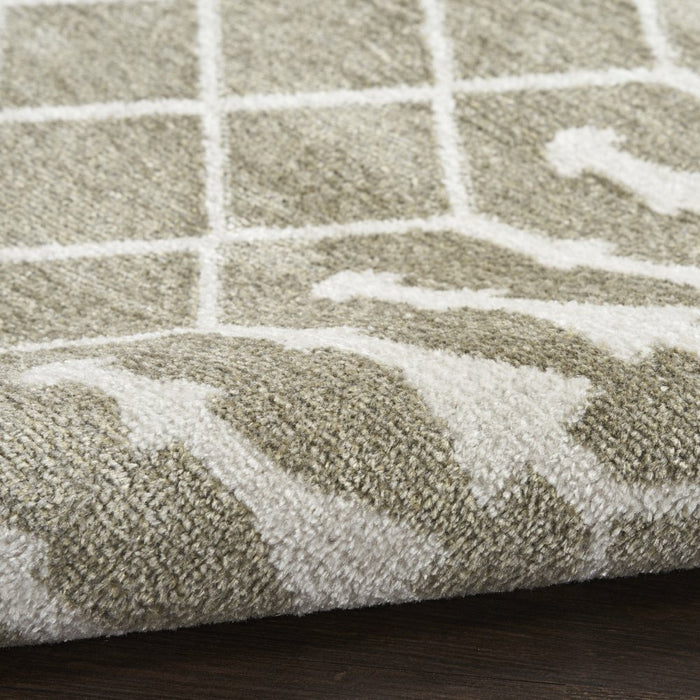 Close-up of a textured rug with a grid pattern on a wooden floor.