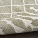 Close-up of a textured rug with a grid pattern on a wooden floor.