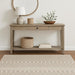 Wooden console table with decorative items in a room with a patterned rug.