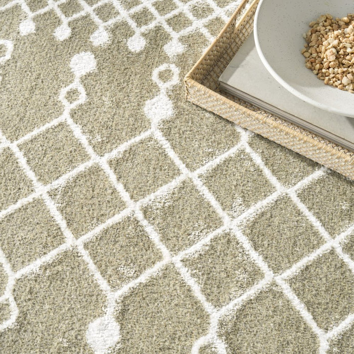 Close-up of a textured beige carpet with white geometric patterns, featuring a bowl and tray on top.
