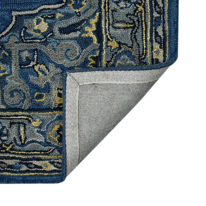 Close-up of a blue and gold patterned rug corner with gray backing
