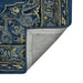 Close-up of a blue and gold patterned rug corner with gray backing