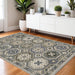 Decorative rug with geometric pattern in a room with a white sideboard and plants.