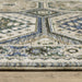 Close-up of a patterned rug with blue and beige colors on a wooden floor.