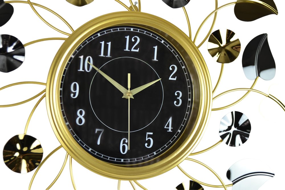 Decorative wall clock with gold frame and black face on a white background
