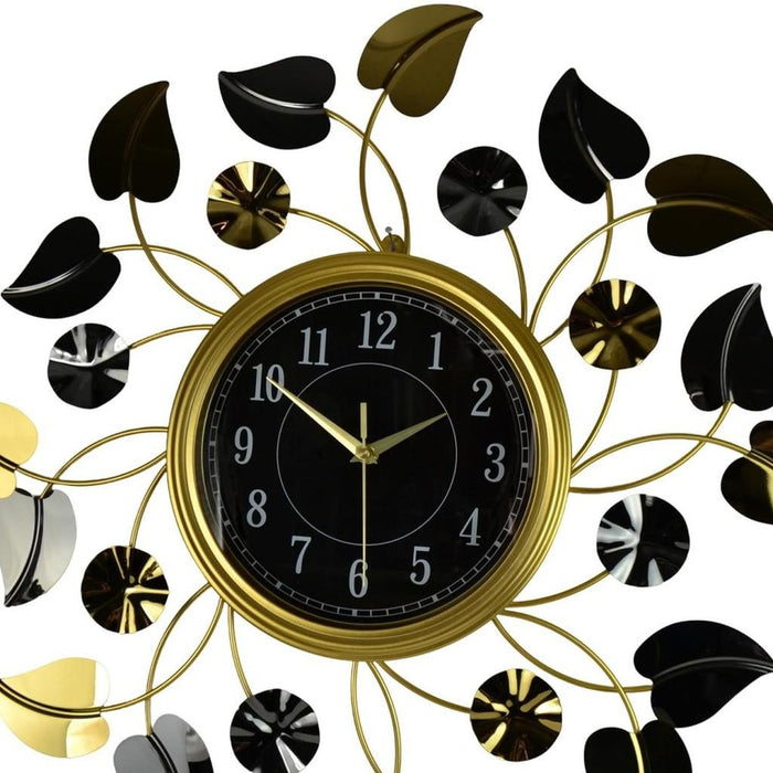 Decorative wall clock with gold and black leaf design on a white background