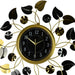 Decorative wall clock with gold and black leaf design on a white background