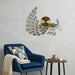 Decorative wall clock with peacock design in a living room setting.