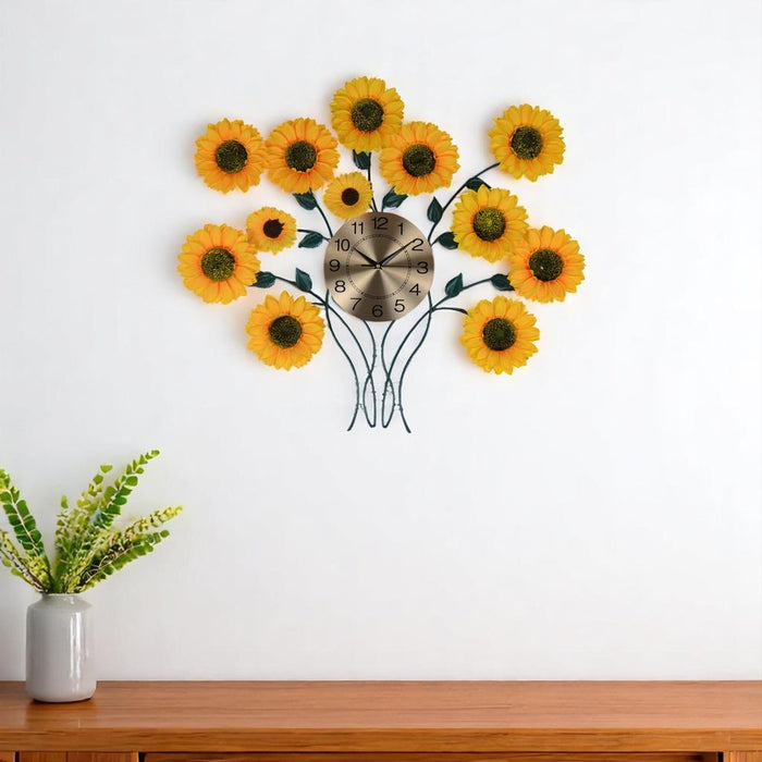 Decorative wall clock with sunflower design on a white wall above a wooden surface.