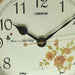 Close-up of a clock face with floral design and 'Lisheng' branding