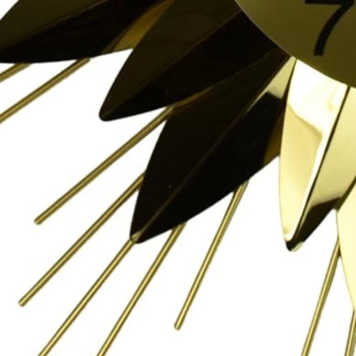 Gold and black decorative object with pointed ends on a white background