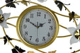 Decorative wall clock with gold frame and floral designs on a white background