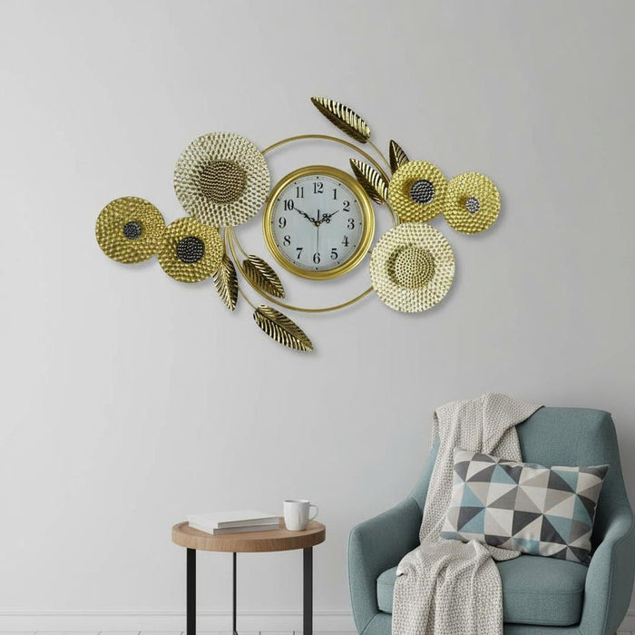 Decorative wall clock with floral designs on a wall above a blue armchair.