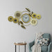 Decorative wall clock with floral designs on a wall above a blue armchair.
